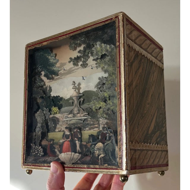 Vintage shadow box diorama of a Georgian garden with layered paper cut outs for holding desk stationery. The garden has...