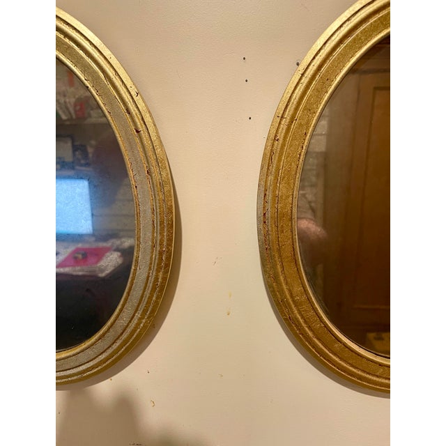 Pair Italian gilt oval mirrors. Each mirror is 11.5" high x 9.5" wide x 1" deep. Wire on back for hanging. Good overall...