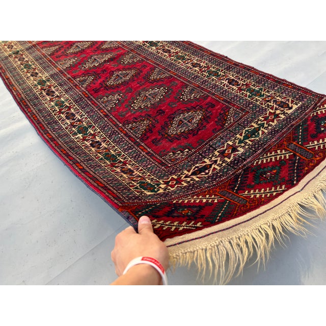 A refined vintage Yomut Turkmen runner showcasing the tribe's prized "Kepse" gul — a single vertical column of lozenge-...
