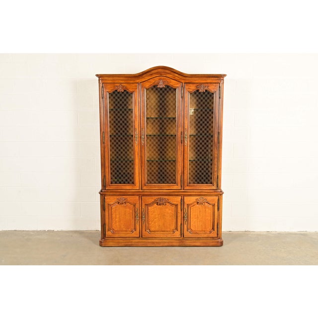 A beautiful French Provincial Louis XV style lighted breakfront bookcase or dining cabinet By Henredon USA, Circa 1970s...
