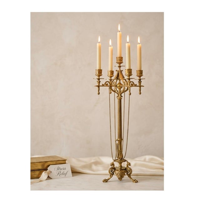 A beautifully detailed antique French five-light candelabra featuring a fluted column, draped chains, scrolling arms, and...