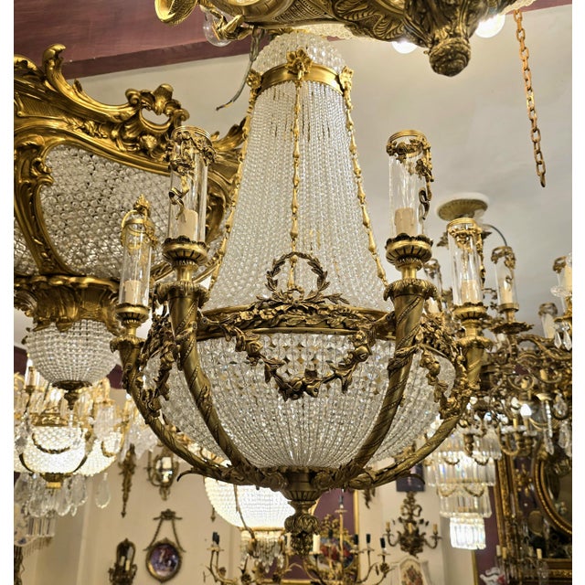 This one-of-a-kind chandelier blends grand sophistication with exquisite detail. Featuring sculpted bronze arms decorated...