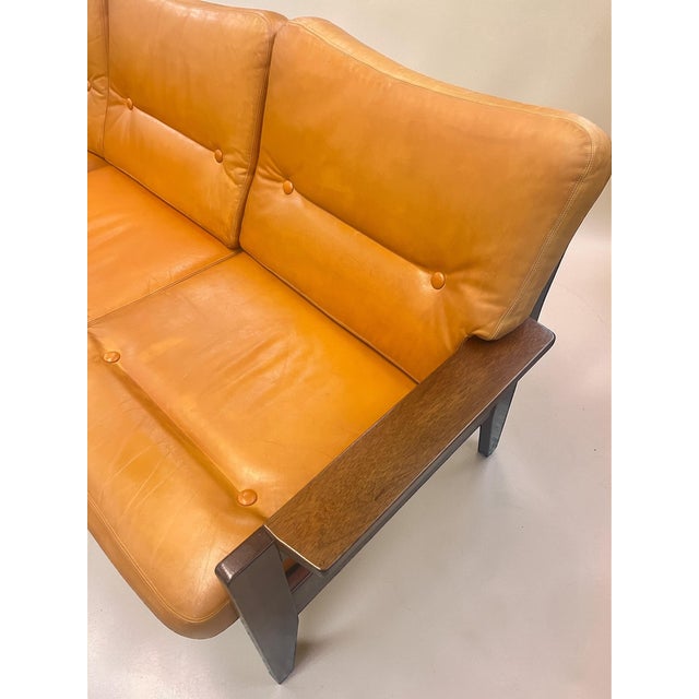 A beautiful vintage sofa from the 1970s with a solid wood frame and removable leather cushions in warm cognac and mustard...