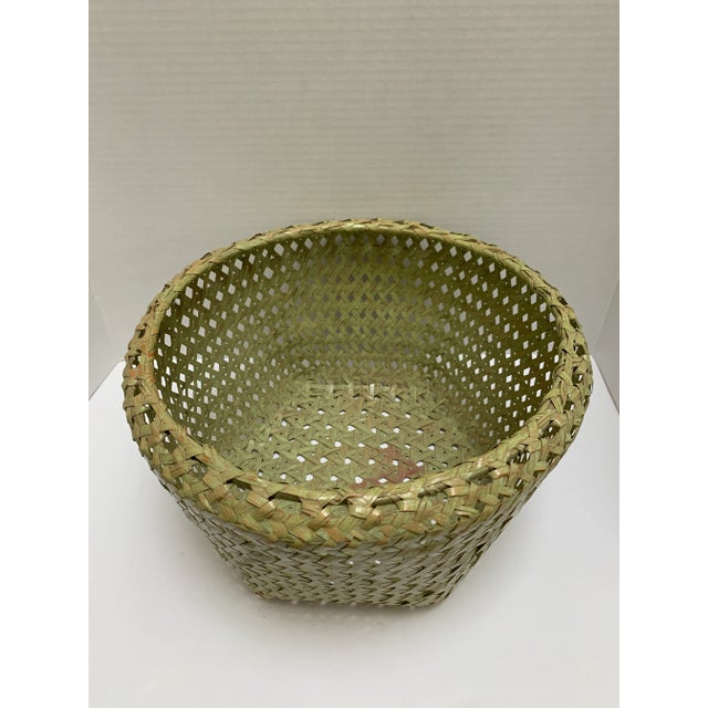 Unusual rustic woven storage basket in celery or celadon green with open weave pattern.
