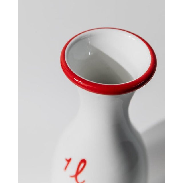 This vintage ceramic jug from 1970s Italy features a classic rural design, handmade in white ceramic with a red rim and...