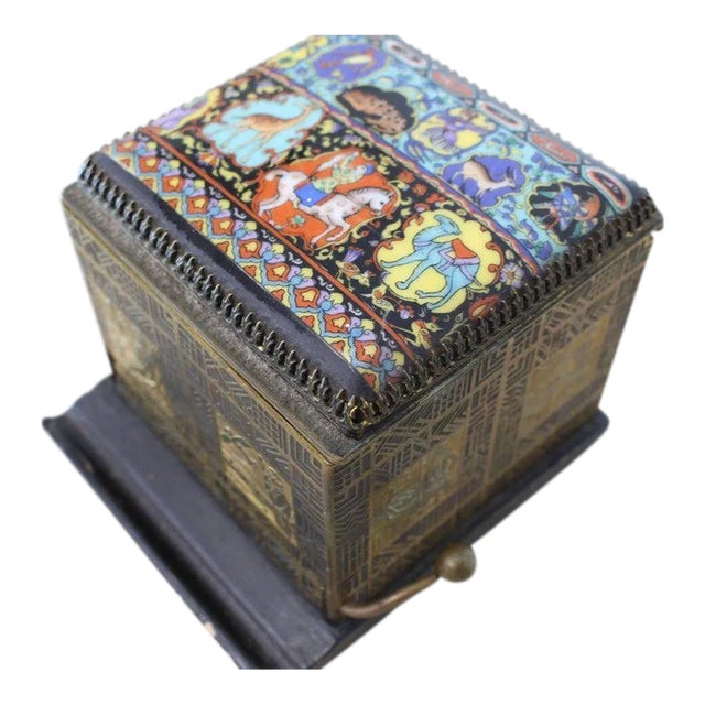 This is a very nice cigarette dispenser box from the 1940s. The piece features a painted porcelain top and etched metal.