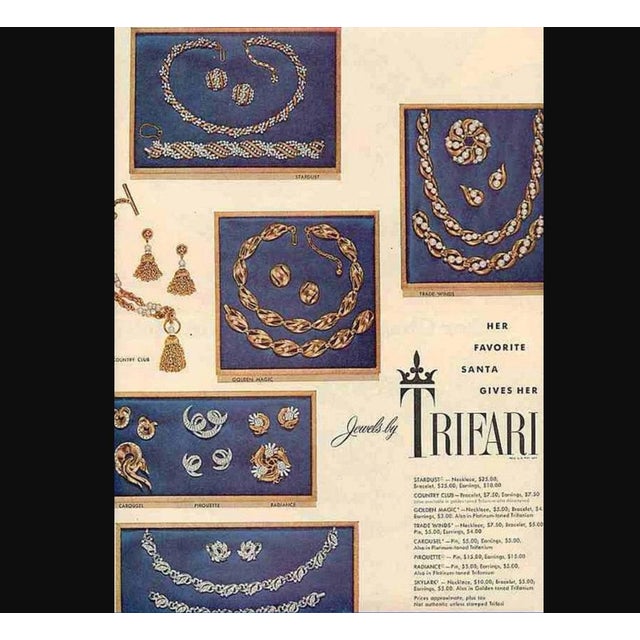 Round goldtone with two twisted goldtone lines down the front with clear rhinestones in the shape of flowers down the...