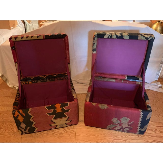 A pair of footstools with hinged tops for access to storage inside and upholstered with an old kilim rug.