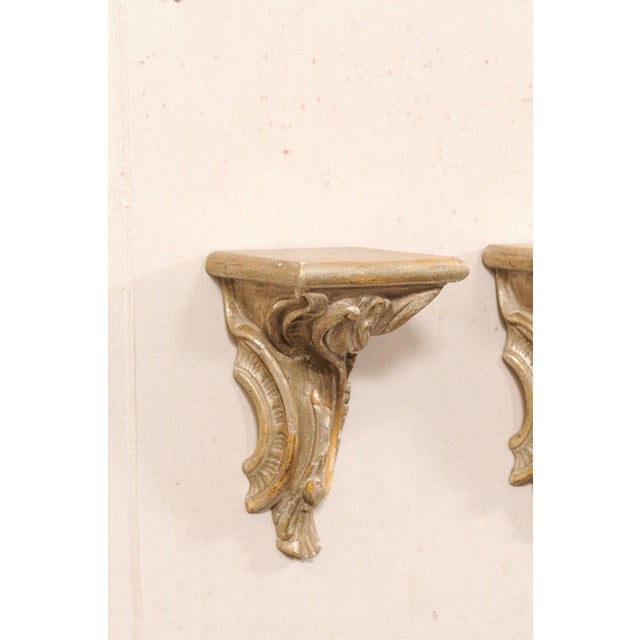 An Italian pair of carved-wood hanging wall brackets from the 19th century. These antique architectural wall decorations...