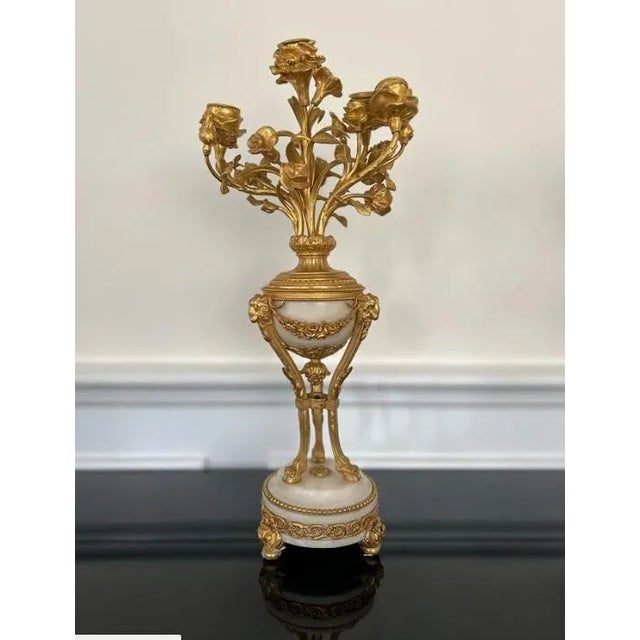 - A pair of guilt bronze cast candelabras in a classical form - Floral design candle holders - Marble base and center...