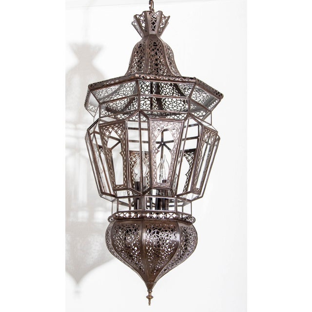 Moroccan Moorish vintage clear glass with intricate metal filigree hanging chandelier. The Moroccan lantern has been...
