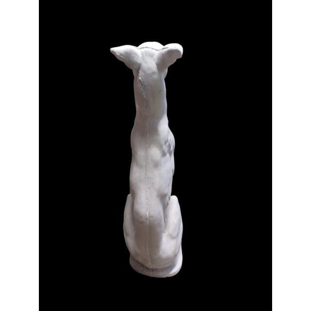 Vintage cast cement statue of a whippet seated.