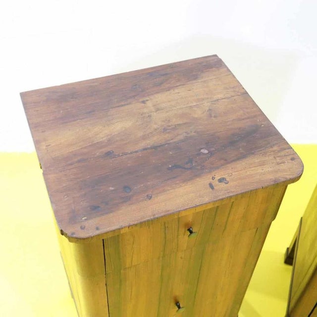 Pair of Restoration nightstands in walnut featuring a drawer and a door.