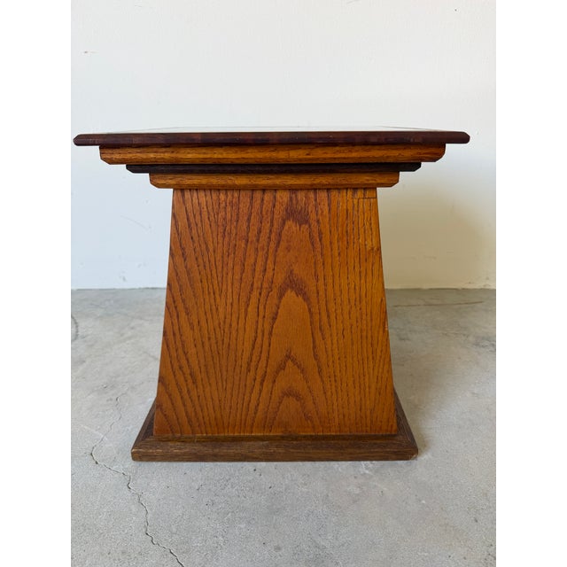 Stylish vintage side table or plant stand featuring a bold geometric pedestal base in warm-toned wood with beautiful grain...