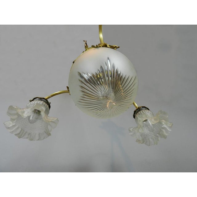 An impressive French Three Arm Ceiling Light from the 1930s with a frosted and cut glass bowl. It is held with a brass...