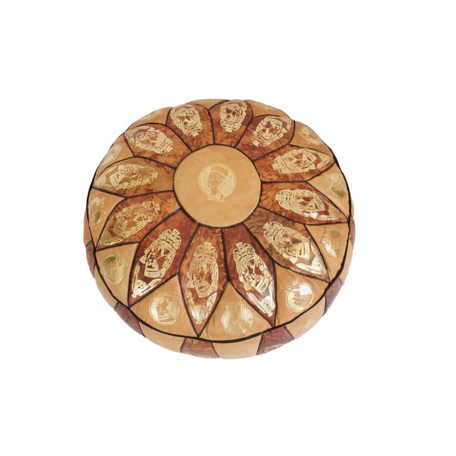 Mid-century leather pouf with metallic Egyptian motif. No maker's mark. Minimal age wear; wear along bottom seam.
