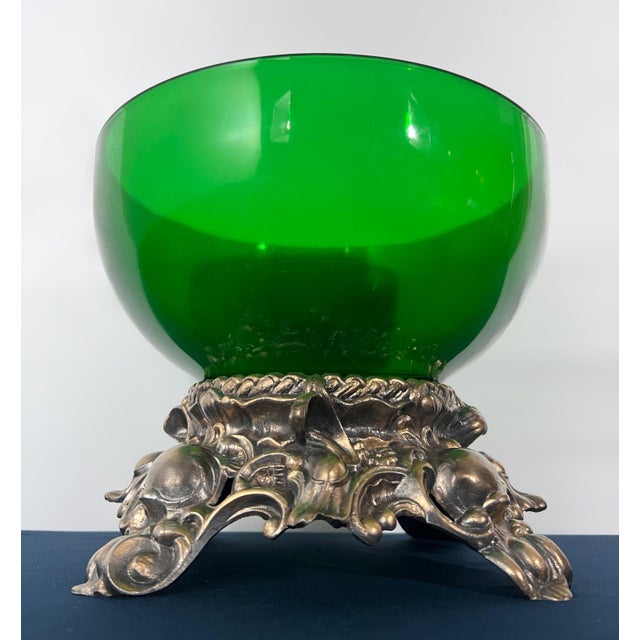 A one-of-a-kind curated vintage centerpiece combining a substantial emerald green art glass bowl with an ornate Hollywood...