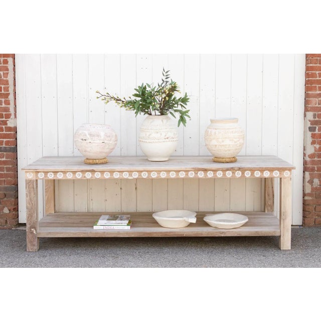 A charming console table with thick square legs and a lower shelf. Made from reclaimed teak, this large reconstructed...