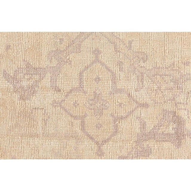This striking antique Oushak rug from the 1920s masterfully embodies the understated elegance and craftsmanship...