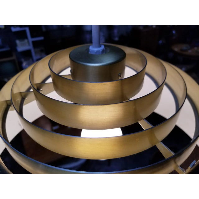 A polished brass pendant chandelier by Lightolier. Designed with 5 concentric, brushed brass louvers over a polished brass...