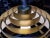 A polished brass pendant chandelier by Lightolier. Designed with 5 concentric, brushed brass louvers over a polished brass...