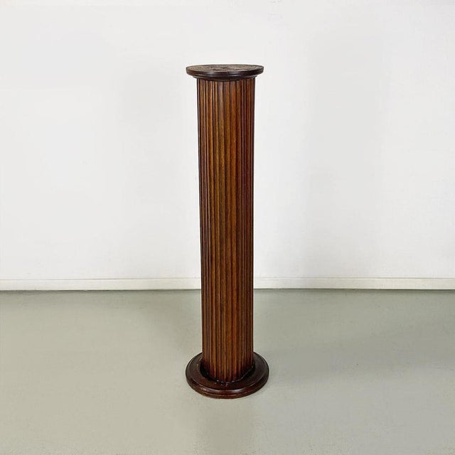 Pedestal or column display stand made of wood with finish the shaped relief, with repeated pattern, irregular cross-...