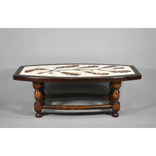 1970s French Designer Coffee Table with Tiled Signed Top This classically designed coffee table features hand drawn oak...