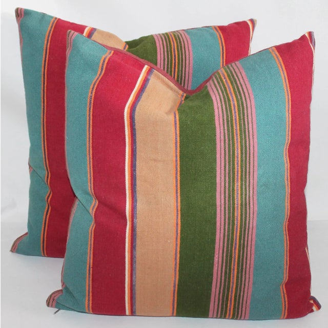 Pair of colorful striped linen pillows with linen backing, down and feather insert and zipper closure on bottom.