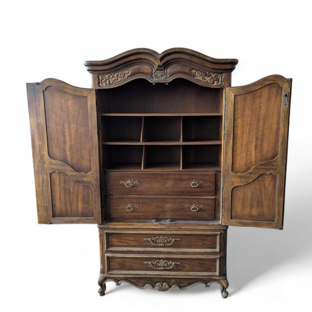A vintage Drexel Brittany Heritage armoire with a tall French Provincial silhouette, carved floral and shell details,...