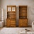 Pair of cottage style oak hutch cabinets with glass doors, lower storage, and warm oak finish. Each cabinet has a tall...
