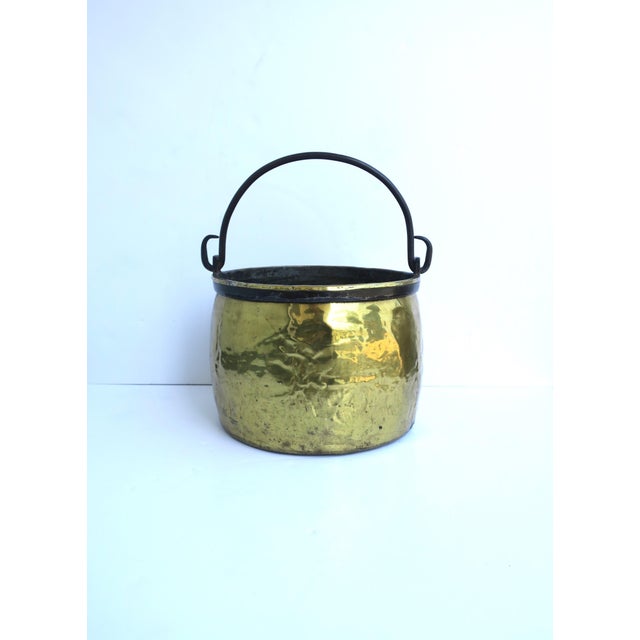 A relatively large Dutch brass fireplace bucket or pot with blacked iron handle, circa 19th century, Holland. Piece is...
