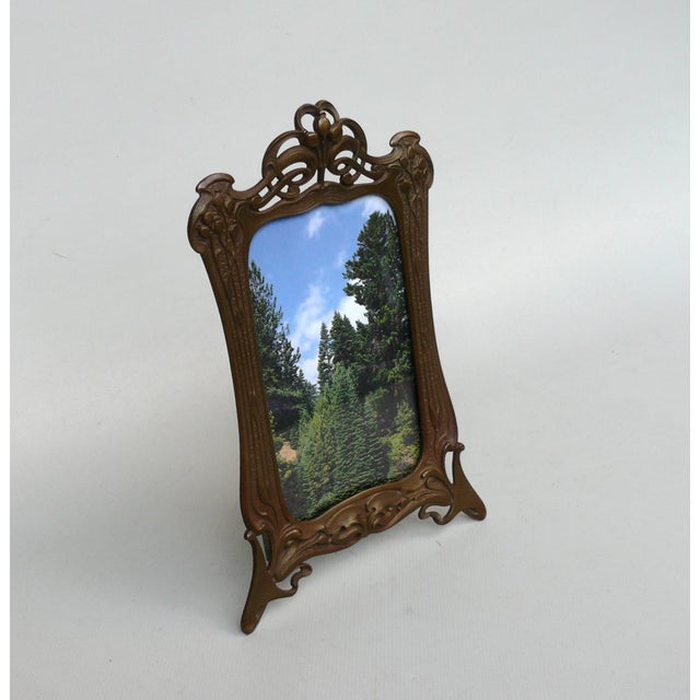 A floral picture frame with lilies of the valley and water lily leaves, made in France during the Art Nouveau period. The...