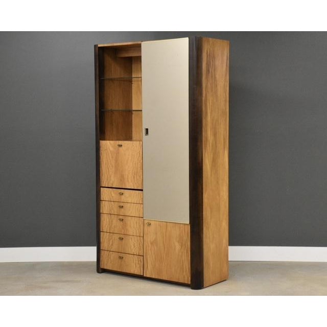 A modern birch color tall dresser armoire with a large door with brass pulls by Founders Furniture. Original finish in...