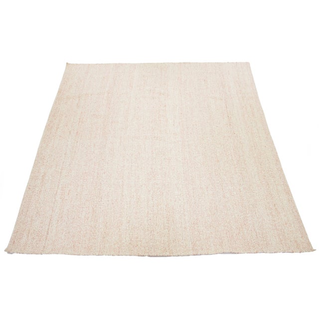 Modern hand-knotted rug made of natural jute and wool, featuring a peach plush field color. This rug measures 12'5'' x...