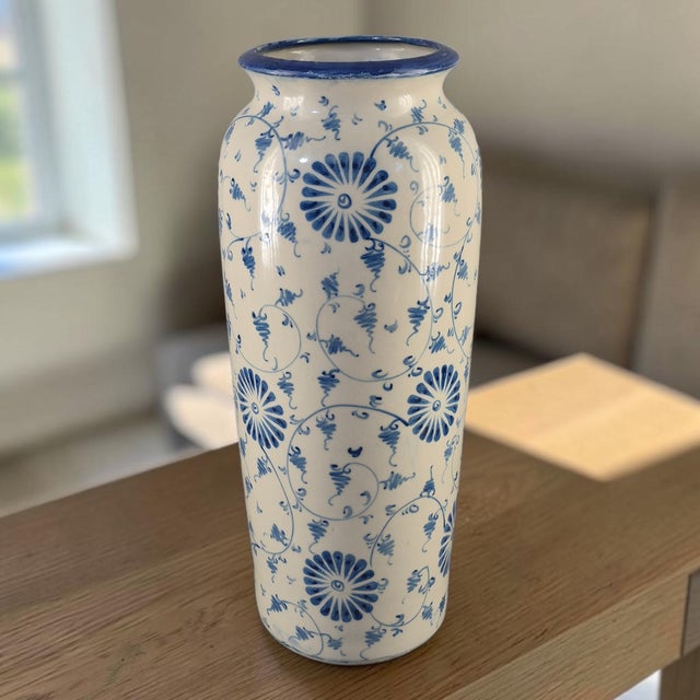 This vintage pottery vase features a beautiful hand-painted floral design in blue and white, typical of the 1970s style....