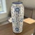 This vintage pottery vase features a beautiful hand-painted floral design in blue and white, typical of the 1970s style....