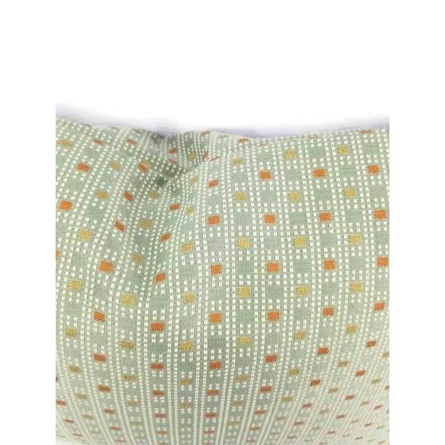 From Kravet Fabrics is Check Out in the color Poolside. This pillow feathers a check plaid pattern with colors of orange...