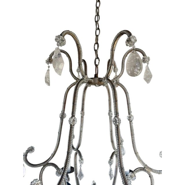 An elegant eight-light chandelier composed of scrolling iron arms wrapped in crystal beading, adorned throughout with rock...
