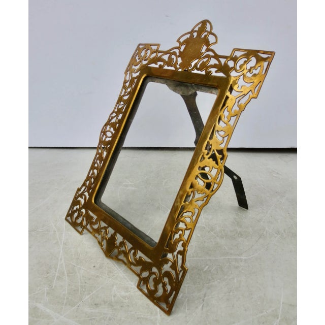 Antique Brass photo frame. Cut-out pattern that silhouettes the scrolling vines and floral patterns. A sliding glass panel...