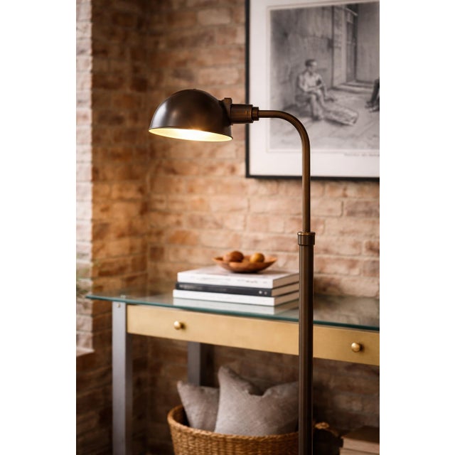 A refined pair of adjustable brass crane arm floor lamps, designed with both form and function in mind. Their...