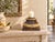 Start at the foot. A square plinth wears a diamond lattice pattern in chocolate brown, with small green and teal accents...