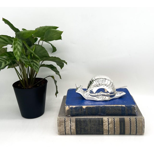 Delightful and unusual caviar dish in the form of a stylized snail, crafted from silver-plated EP zinc alloy. The hinged...