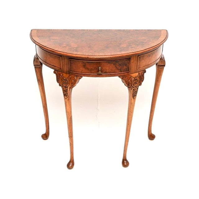 A stunning antique burr walnut console table, made in England and dating from around the 1900-1910 period. It is of...