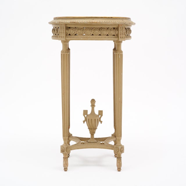 Side table or gueridon from France made of solid wood construction that features the original paint in an antique cream...