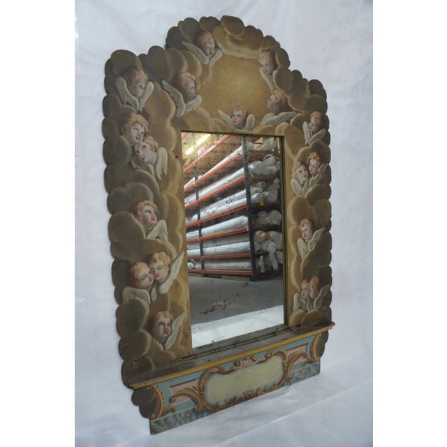 19th-century Italian mirror with shelf Hand-painted angels among dramatic clouds.. There is a shallow shelf below the...