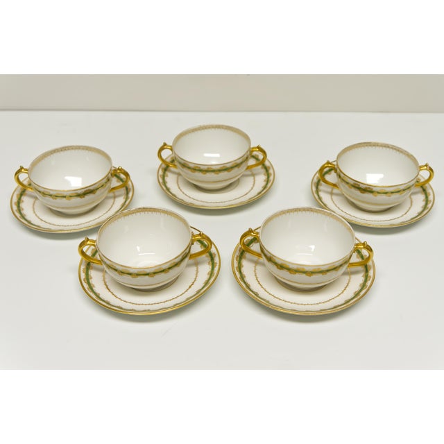 A set of 5 porcelain bouillon cups with matching saucers by CH Field Haviland Limoges featuring a detailed green and gold...