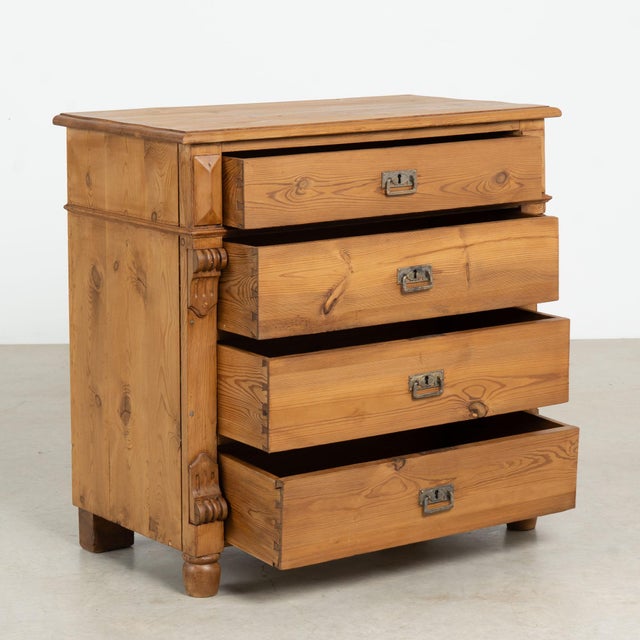 This pine chest of four drawers has columns accenting the central three drawers which are slightly inset creating...