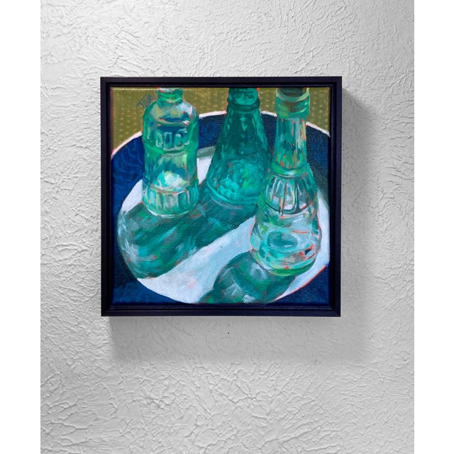 This artwork features three vintage glass bottles resting on a circular surface, their vibrant green hues contrasting with...