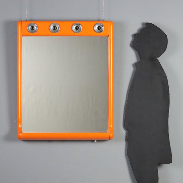 1970s vintage mirror designed for bathroom use, featuring an orange plastic frame that adds a lively and distinctive...