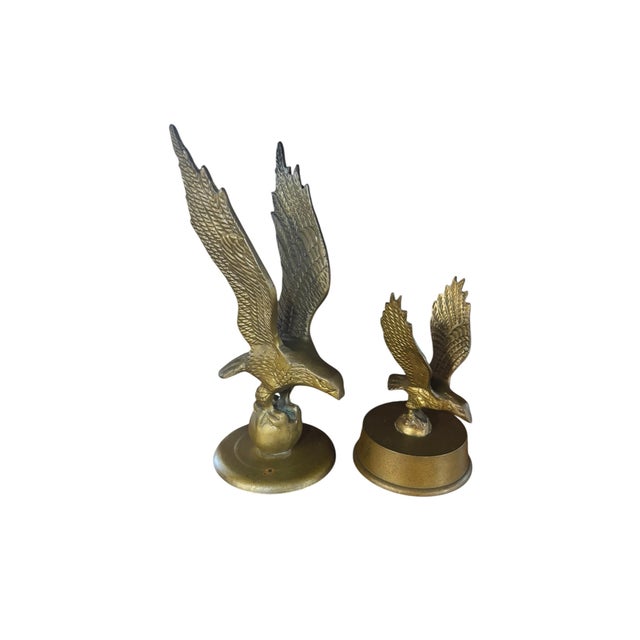 A handsome pair of vintage cast brass eagle sculptures depicting eagles in dramatic landing poses with wings fully...